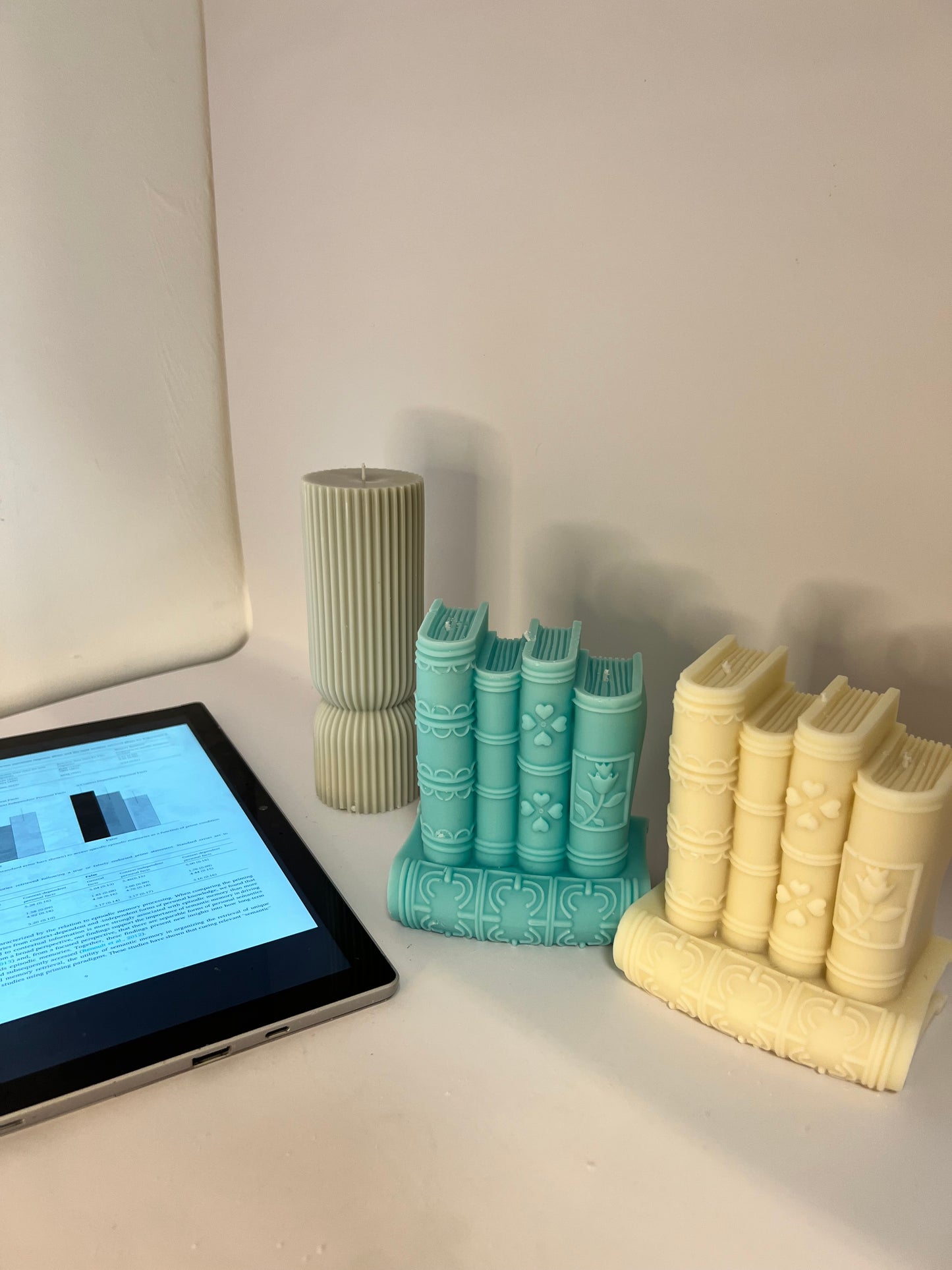 “Luxury soy wax candle trio with two book-shaped candles in beige and blue inspired by Baccarat Rouge 540, and one gray pillar candle with Millionaire Man scent – handmade sculptural candles for home decor and gifting
