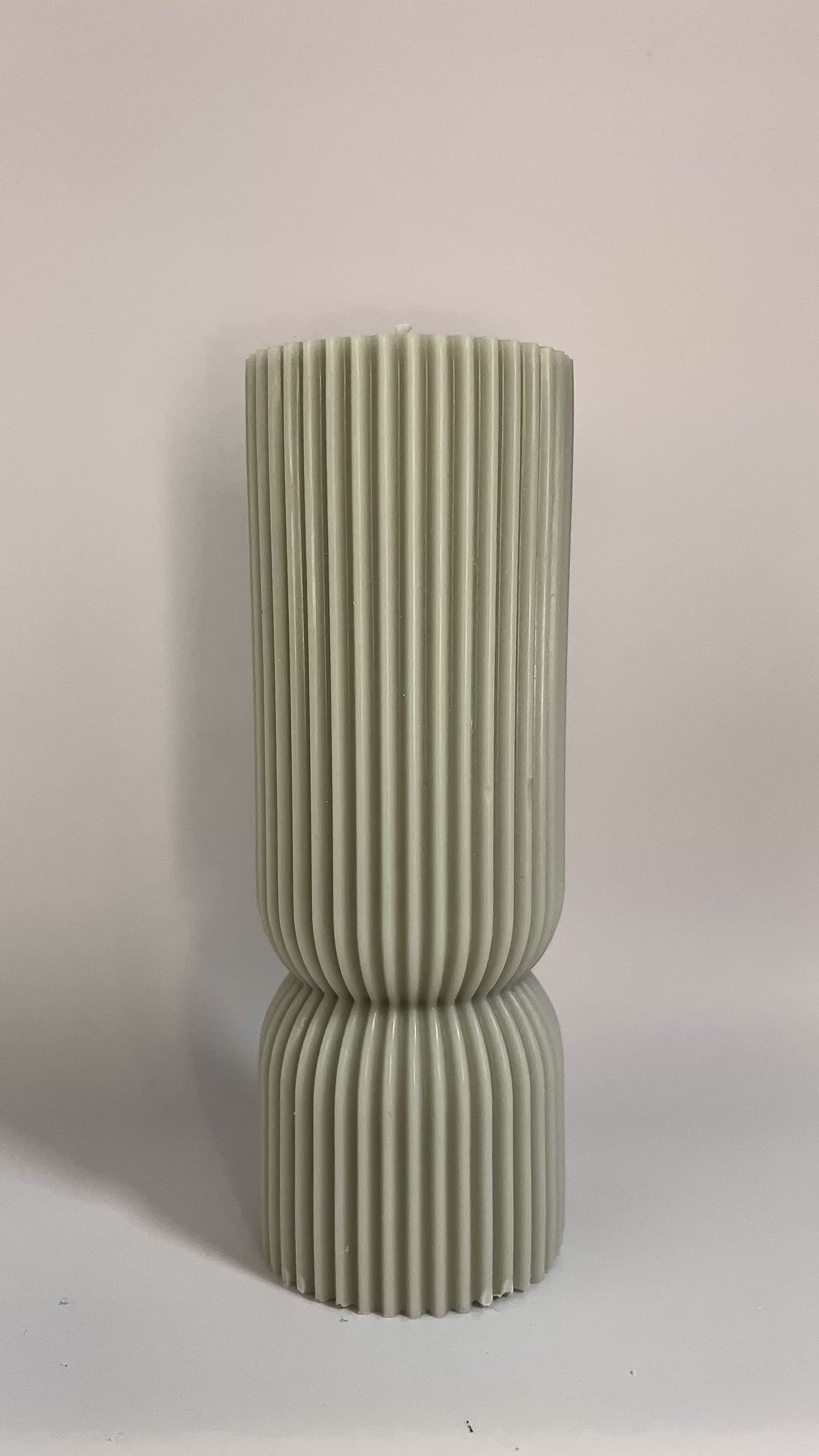 Scented pillar candle in soft pastel tones, featuring Millionaire Man inspired aroma for upscale ambiance