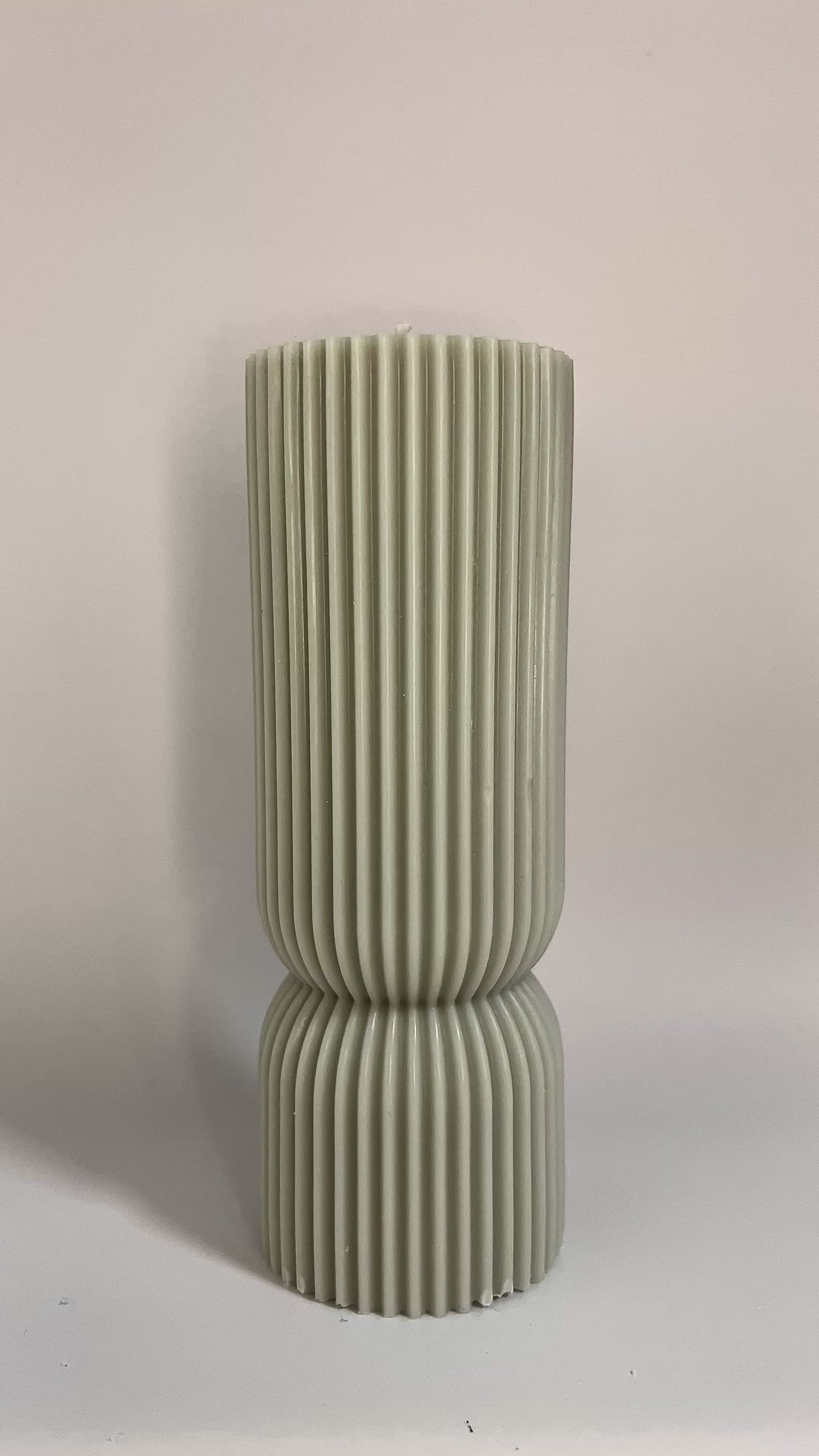 Scented pillar candle in soft pastel tones, featuring Millionaire Man inspired aroma for upscale ambiance