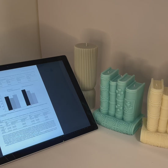 “Luxury soy wax candle trio with two book-shaped candles in beige and blue inspired by Baccarat Rouge 540, and one gray pillar candle with Millionaire Man scent – handmade sculptural candles for home decor and gifting
